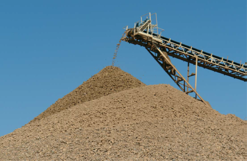 montaña de áridos que culmina en una máquina transportadora